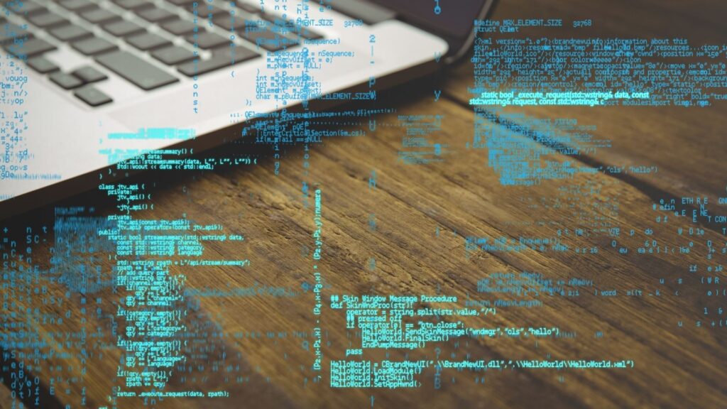 Il codice su sfondo di un computer portatile simboleggia la protezione digitale di Hawke Transit System contro attacchi informatici e frodi via email.
